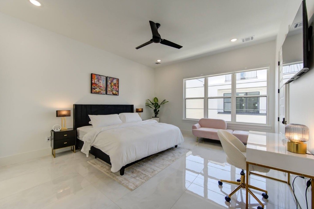 5702 Fairdale Lane, Unit C Houston, TX 77057 - Photo 24 of 47 a bedroom with a bed a couch and a flat tv screen on dresser