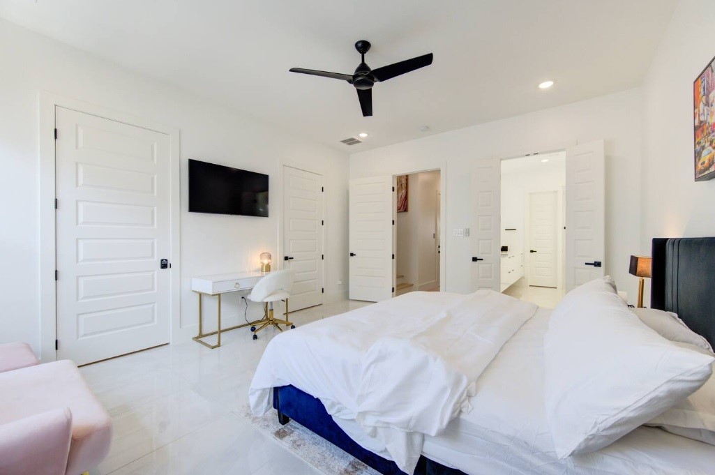 5702 Fairdale Lane, Unit C Houston, TX 77057 - Photo 25 of 47 a bedroom with a bed a flat screen tv and a chandelier