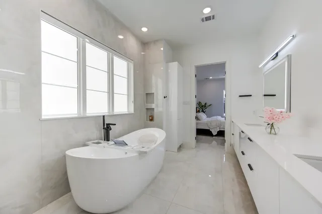 a bathroom with a bathtub and 2 sink