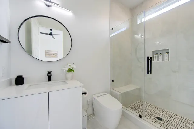 a bathroom with a sink a toilet and a mirror