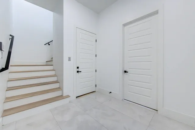 a spacious bedroom with two beds and potted plant