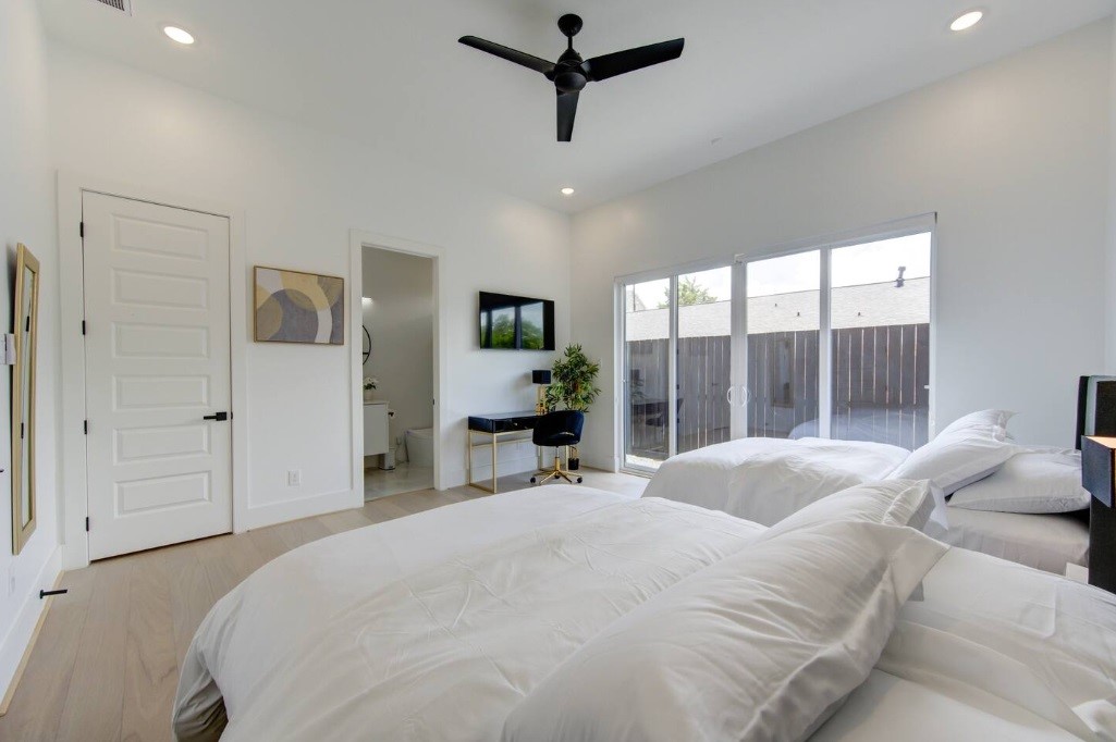 5702 Fairdale Lane, Unit C Houston, TX 77057 - Photo 8 of 47 a bedroom with a bed a large window and a chandelier