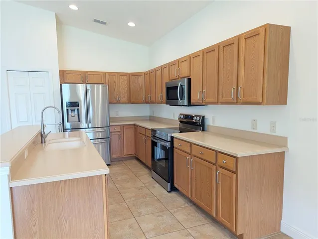 a kitchen with a sink a stove top oven and white cabinets