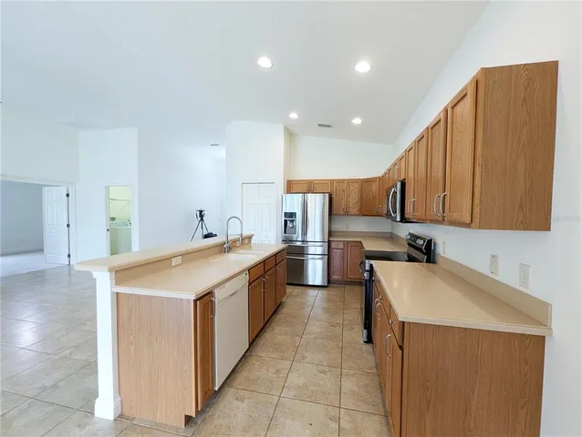 a kitchen with stainless steel appliances granite countertop a sink a stove and a refrigerator