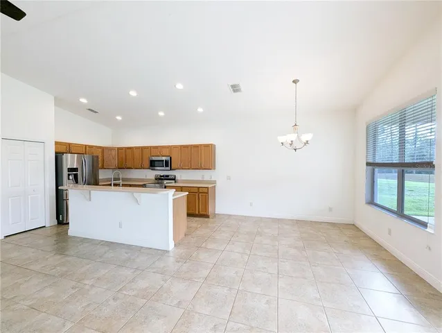 a view of kitchen with stainless steel appliances granite countertop a stove top oven a sink a counter space and cabinets