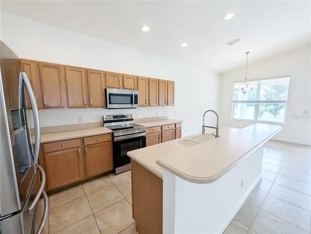 a kitchen with granite countertop a sink appliances and cabinets