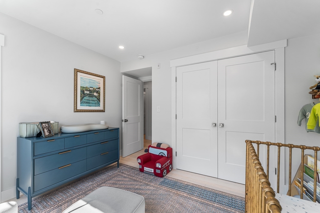 11 Lowell Street, Unit B Arlington, MA 02476 - Photo 16 of 31 a spacious bedroom with a bed and a chandelier