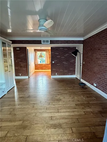 a view of empty room with wooden floor and fireplace