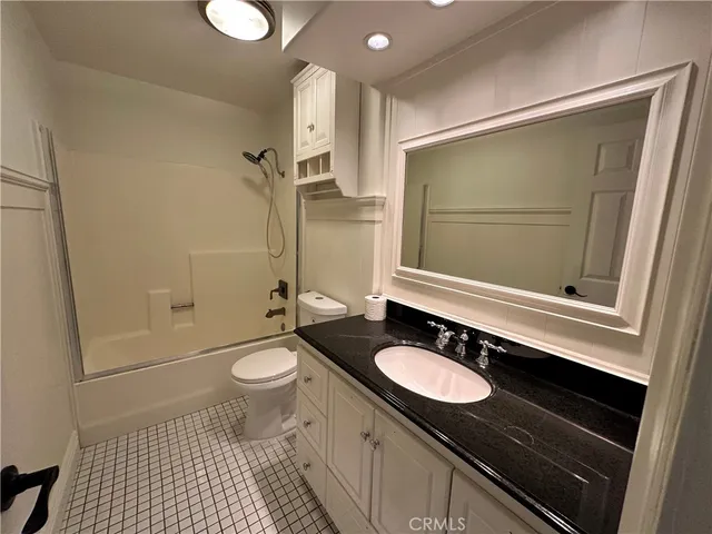 a bathroom with a sink a toilet a mirror and shower
