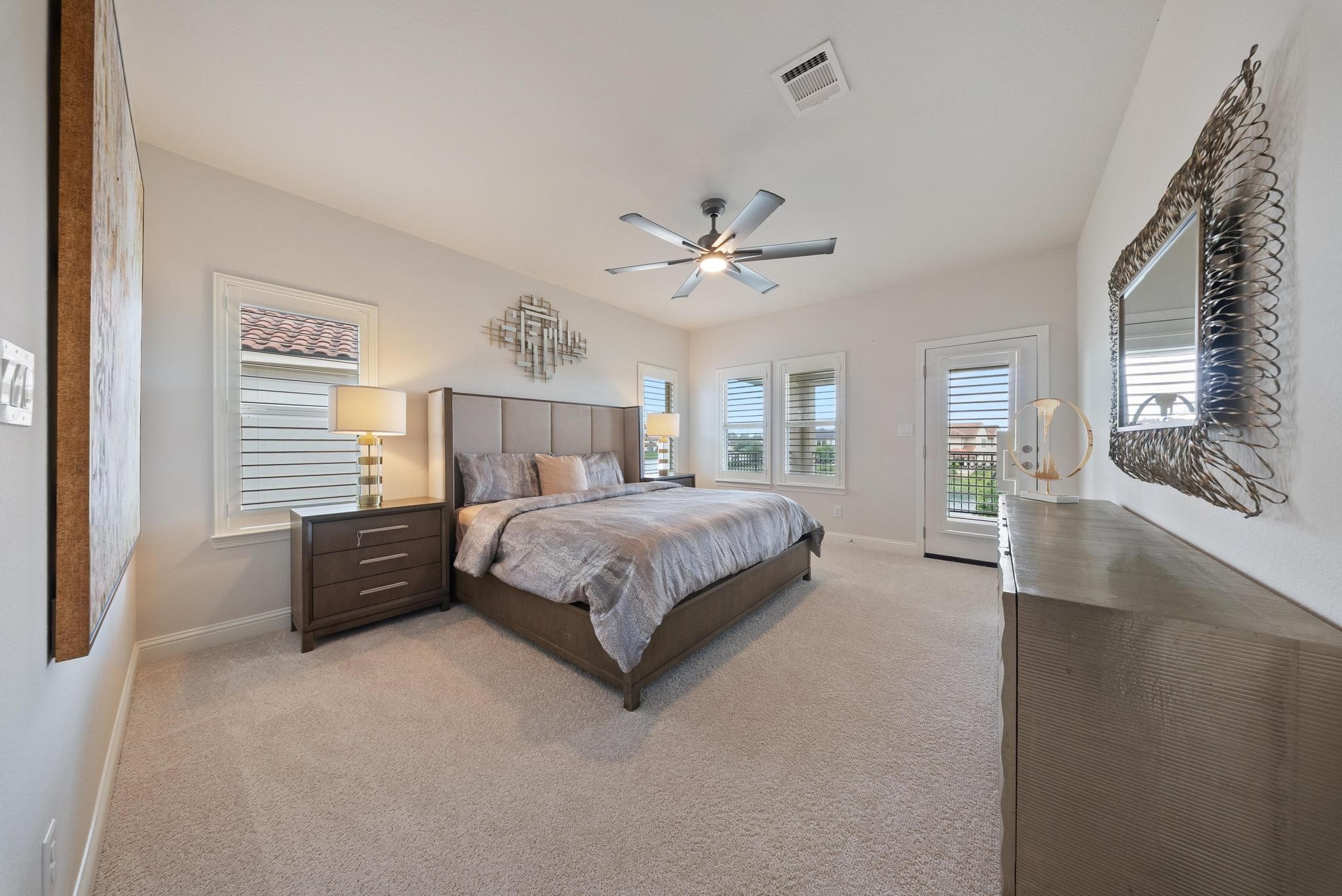 5403 Rouchel Brook Lane Sugar Land, TX 77479 - Photo 26 of 42 Generously sized bedroom with plush carpeting, natural light, and a relaxing retreat feel with access to the covered extended balcony. Features own private en-suite bathroom. Large enough to be a third primary suite in the home! Room features custom plantation shutters.