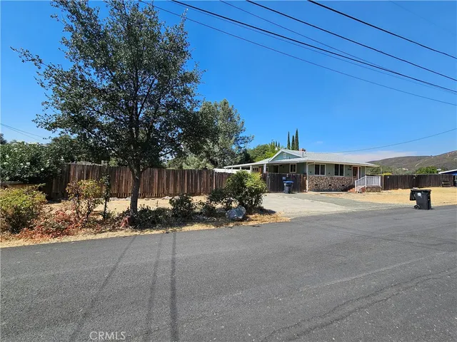 a view of a building with sitting area and covered with trees