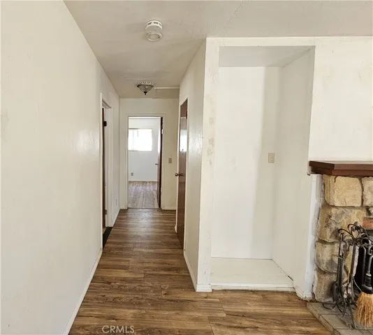 a view of a hallway with wooden floor and a living room