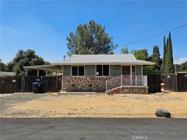 a front view of a house with a yard covered with snow