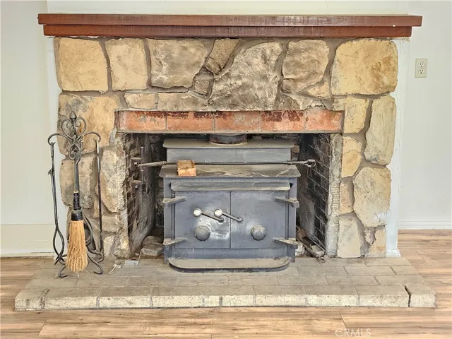 a view of a livingroom with wooden floor and a fireplace