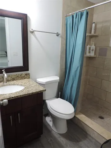 a bathroom with a granite countertop sink toilet and shower