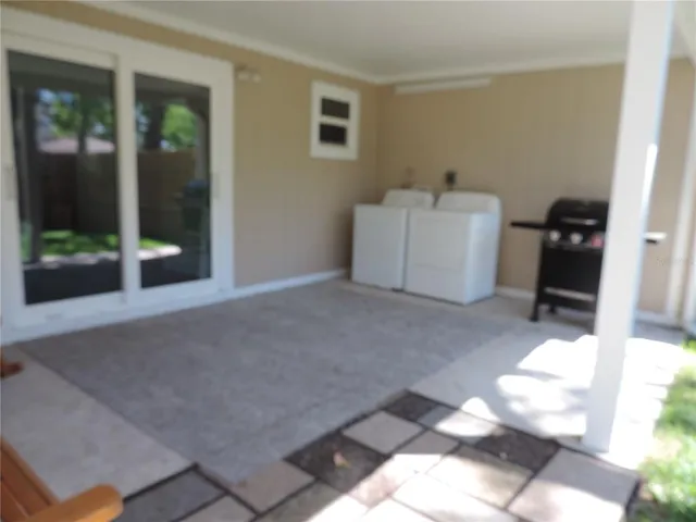a utility room with multiple dryer and door