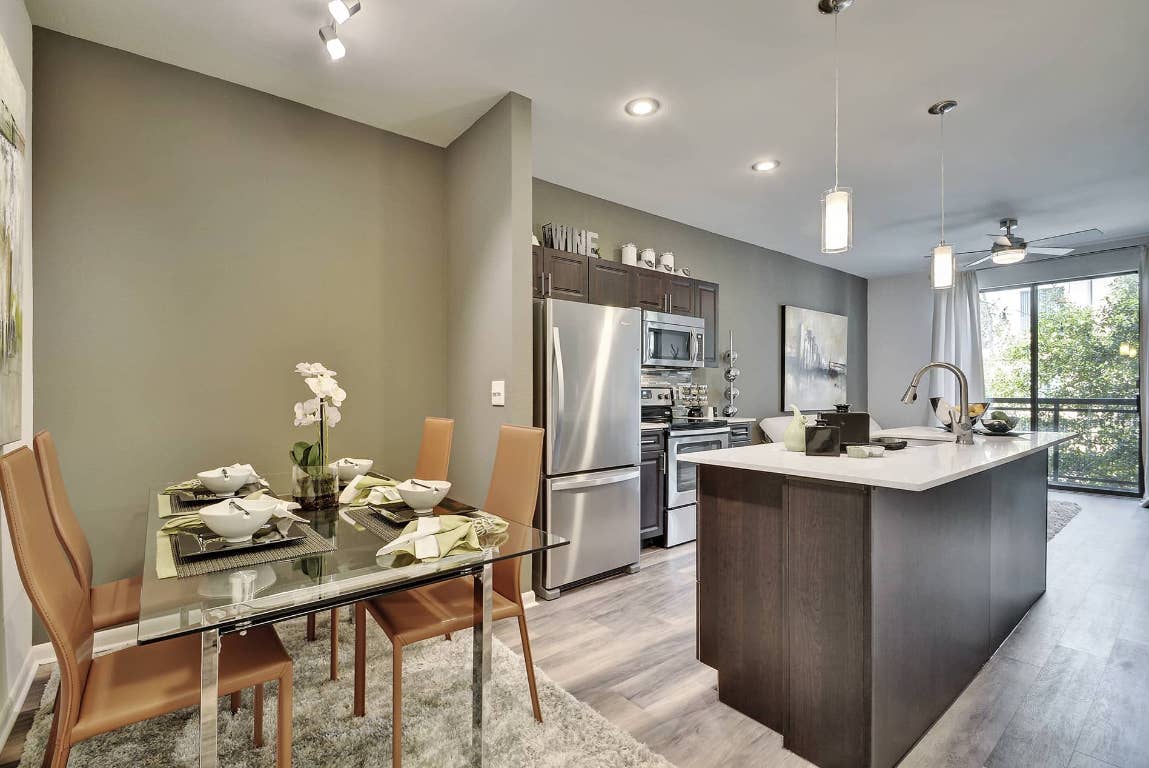 11400 Domain Drive, Unit 1214 Austin, TX 78758 - Photo 4 of 12 a kitchen with a dining table chairs stove and refrigerator
