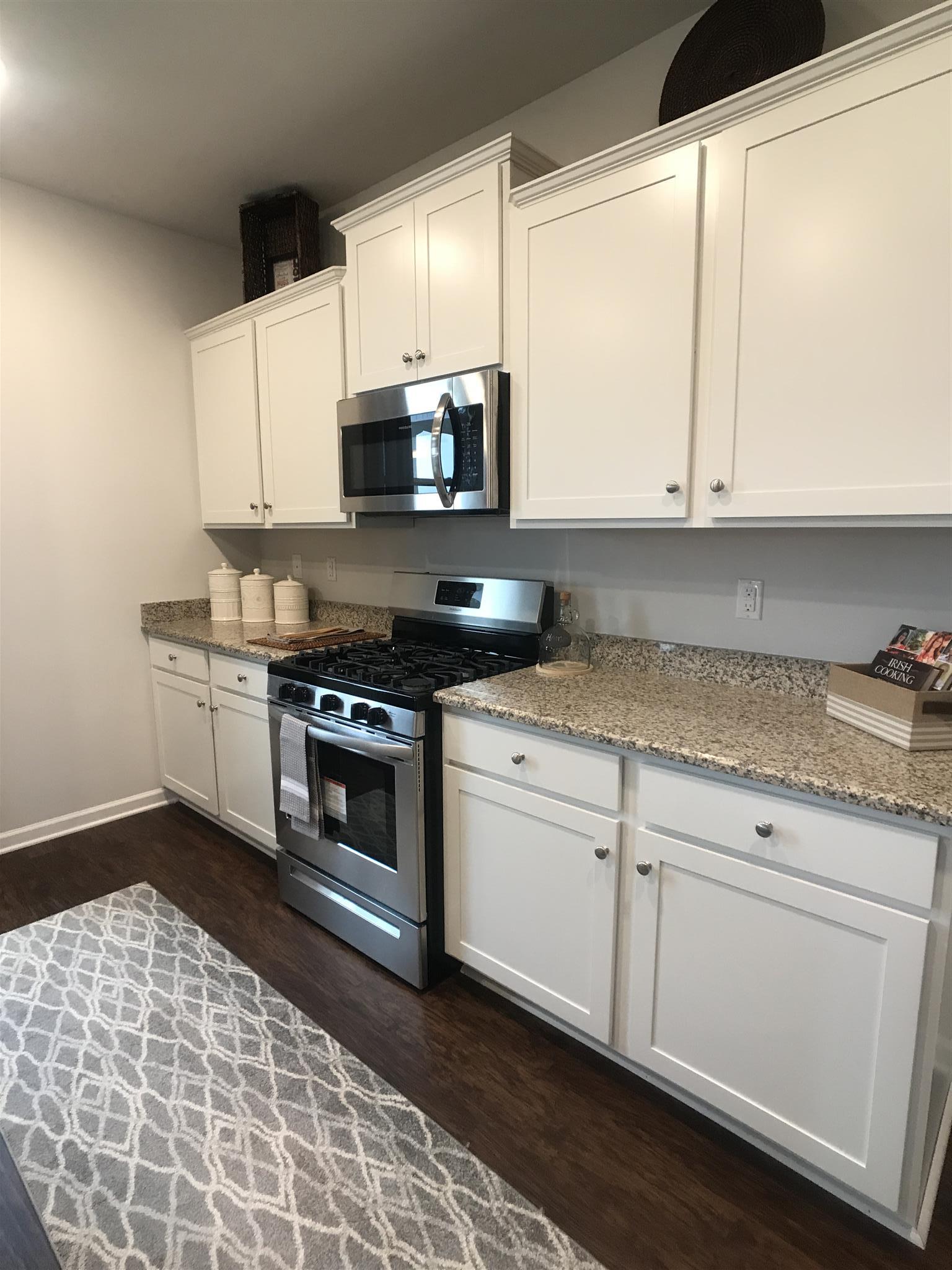 765 Prominence Road, Unit 109 Columbia, TN 38401 - Photo 30 of 30 a kitchen with stainless steel appliances granite countertop a stove a sink and a microwave