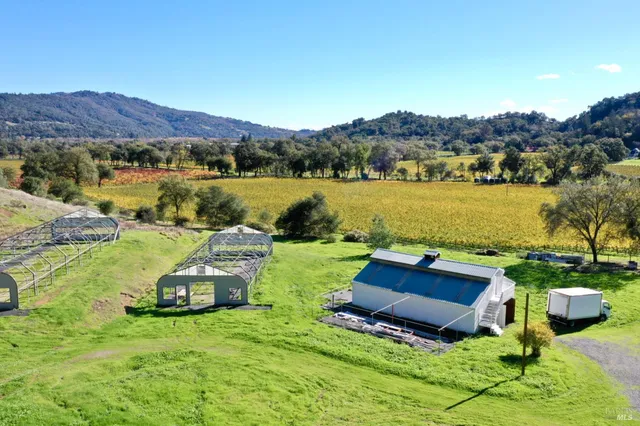 a view of a lush green field with mountains in the background
