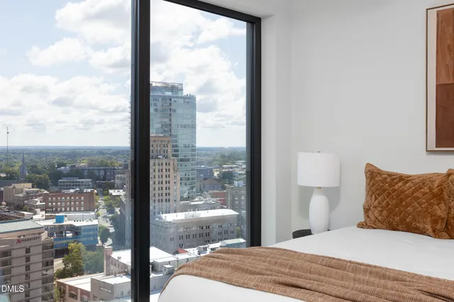 a bedroom with a large window and a bed