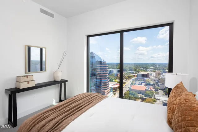 a bedroom with a large window and a bed