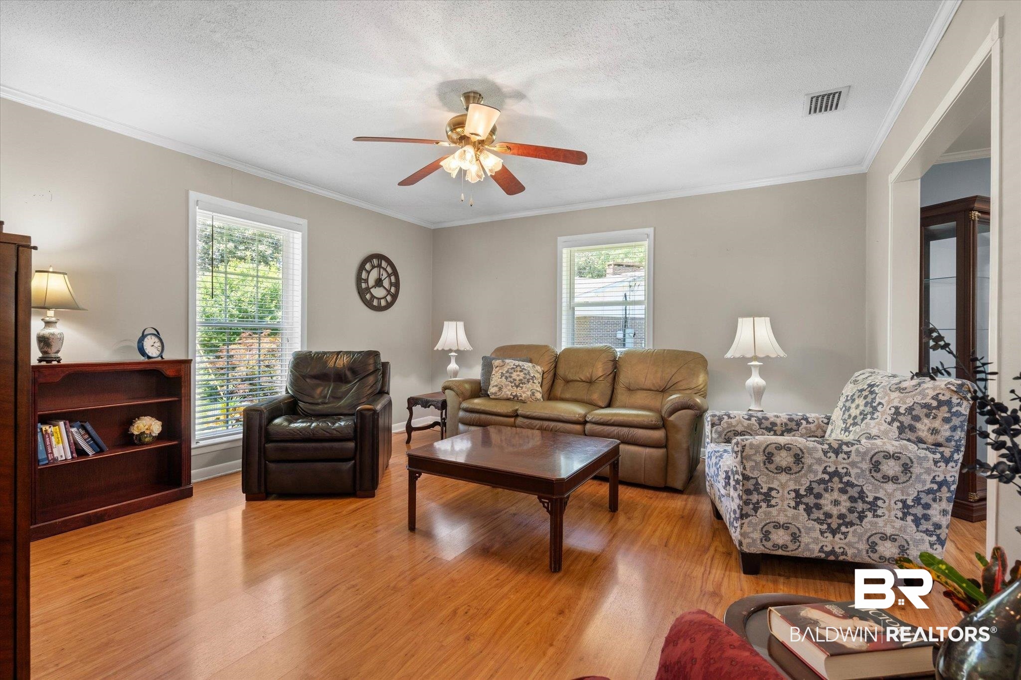 706 Sutherland Drive Chickasaw, AL 36611 - Photo 10 of 33 Living area featuring light wood finished floors, a ceiling fan, visible vents, and ornamental molding