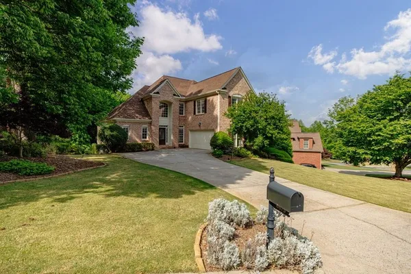 a front view of a house with a yard and a garden