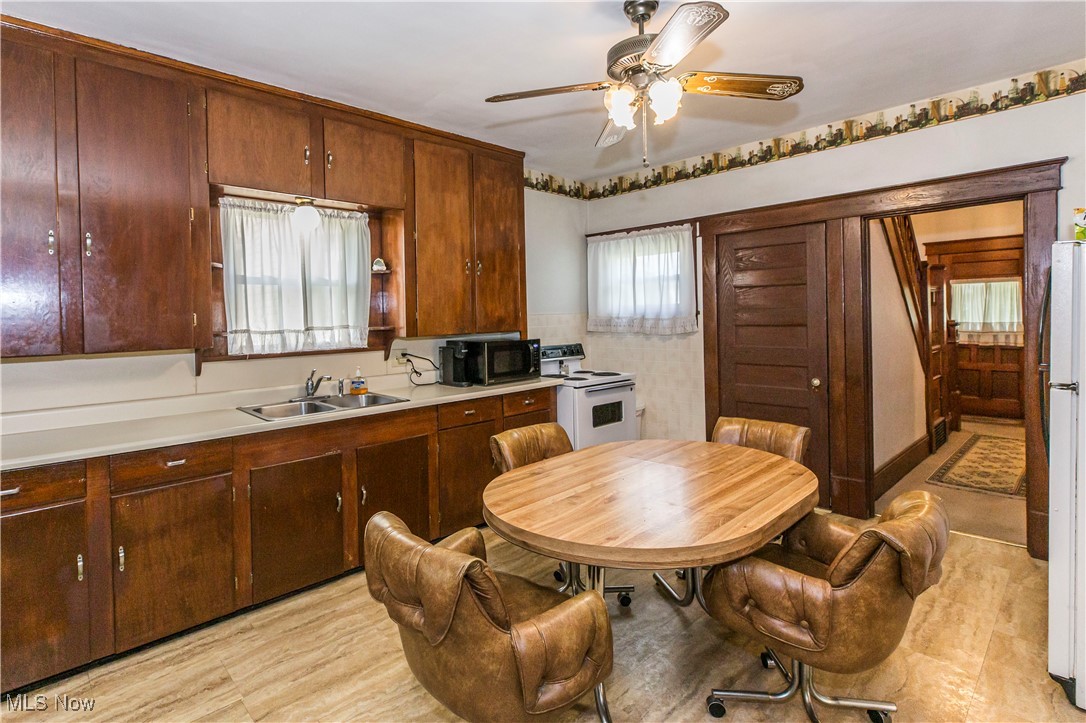 749 Amherst Road Northeast Massillon, OH 44646 - Photo 23 of 41 Kitchen featuring electric range, black microwave, a ceiling fan, light countertops, and light wood-type flooring
