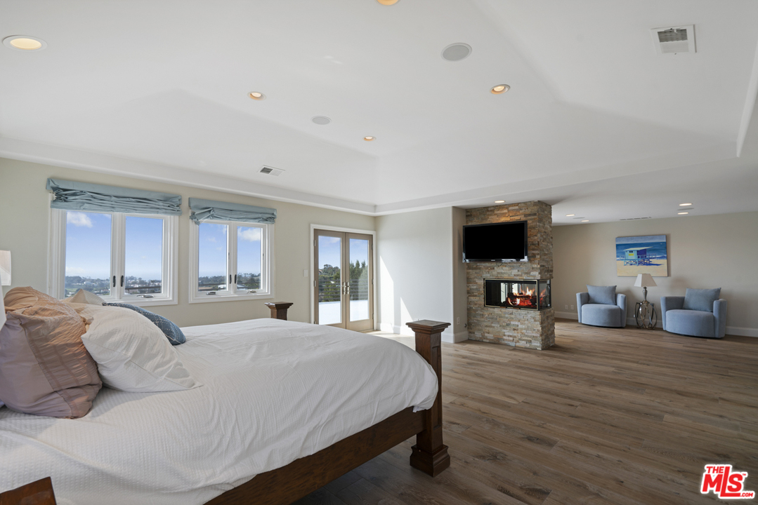 6165 Zumirez Drive Malibu, CA 90265 - Photo 17 of 33 a bedroom with a bed and wooden floor