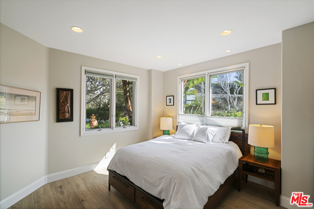 6165 Zumirez Drive Malibu, CA 90265 - Photo 22 of 33 a bedroom with a large bed and a window