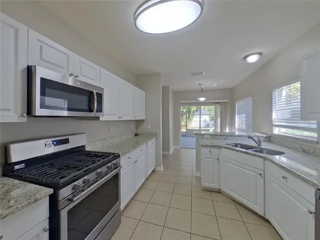 a kitchen with stainless steel appliances granite countertop a sink and stove top oven