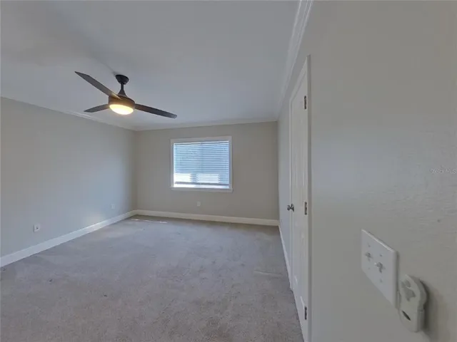 an empty room with a ceiling fan and window