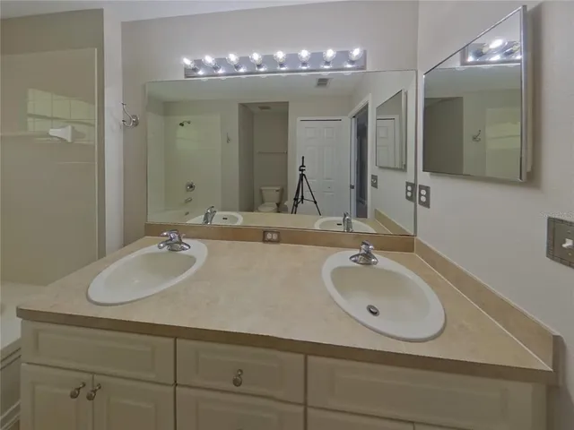 a bathroom with double vanity sinks and a mirror