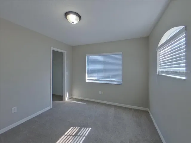 an empty room with windows and closet