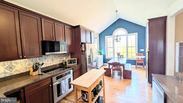 a kitchen with stainless steel appliances a refrigerator a sink and wooden cabinets