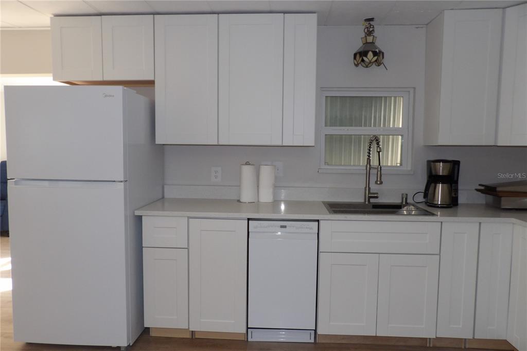 6608 Roosevelt Drive Port Richey, FL 34668 - Photo 18 of 39 a kitchen with granite countertop white cabinets and white appliances