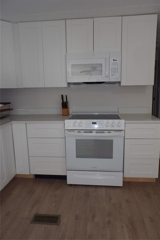 6608 Roosevelt Drive Port Richey, FL 34668 - Photo 21 of 39 a kitchen with white cabinets and white appliances
