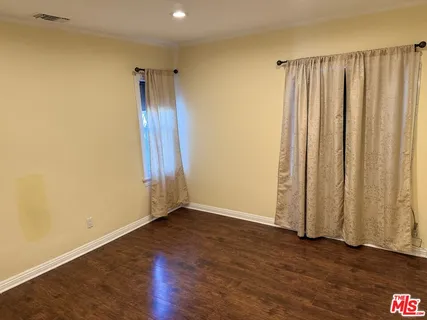 an empty room with wooden floor and a window