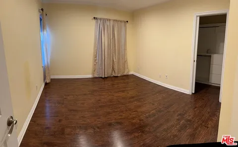 a view of a room with wooden floor and a window
