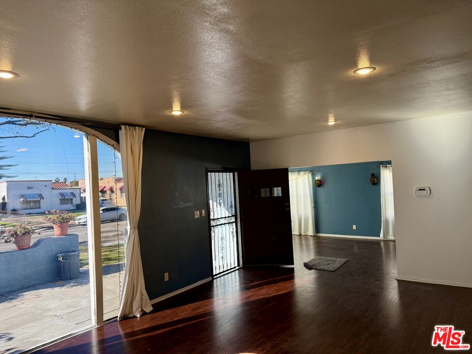 9428 Harvard Boulevard Los Angeles, CA 90047 - Photo 3 of 18 an empty room with wooden floor and windows