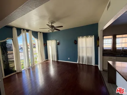 a view of an empty room with a fireplace and wooden floor