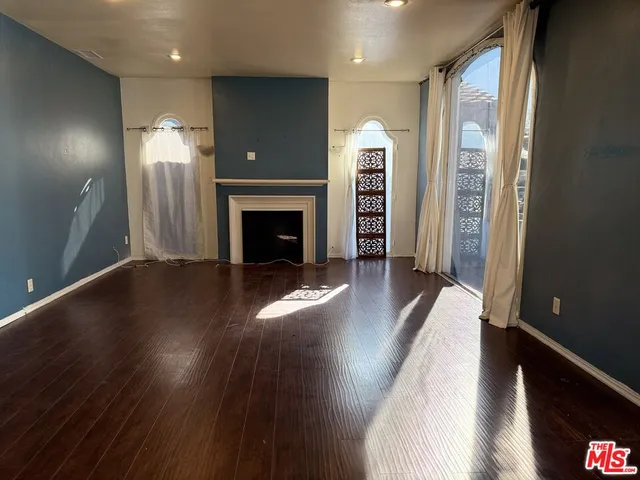 a view of a livingroom with wooden floor and a fireplace