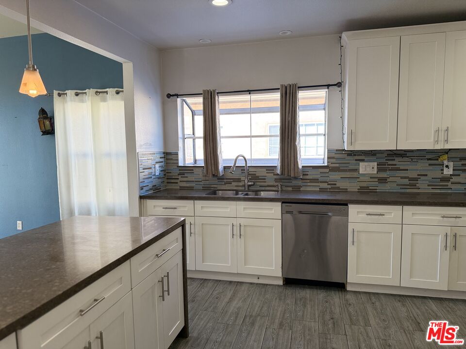 9428 Harvard Boulevard Los Angeles, CA 90047 - Photo 7 of 18 a kitchen with granite countertop white cabinets white appliances and a large window