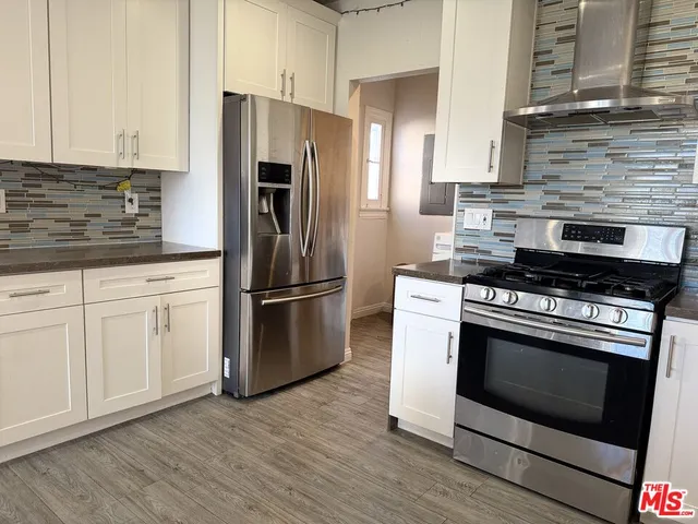 a kitchen with stainless steel appliances granite countertop a stove a refrigerator and a stove