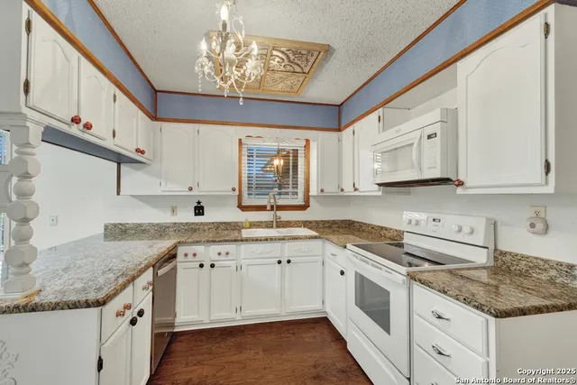 a kitchen with granite countertop a sink and cabinets