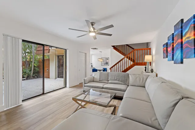 a living room with furniture ceiling fan and a window