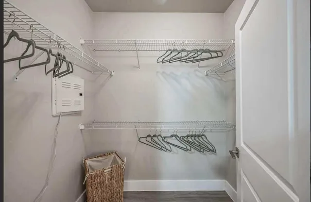 a view of walk in closet with clothes and shoes