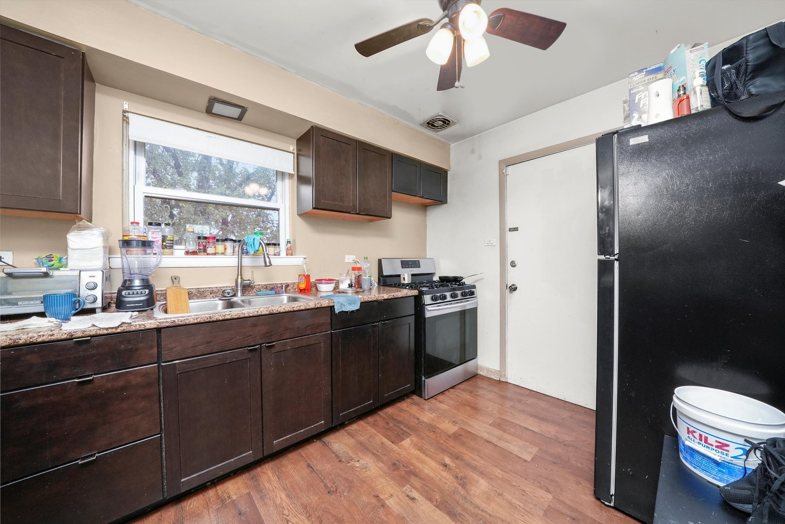 7524 West 63rd Place Summit, IL 60501 - Photo 20 of 44 a kitchen with stainless steel appliances granite countertop a refrigerator a sink dishwasher a stove and a dining table with wooden floor