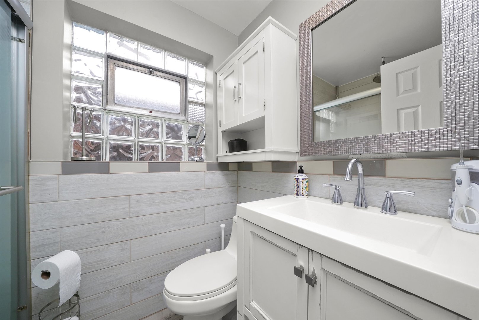 7524 West 63rd Place Summit, IL 60501 - Photo 7 of 44 a bathroom with a toilet a sink and mirror