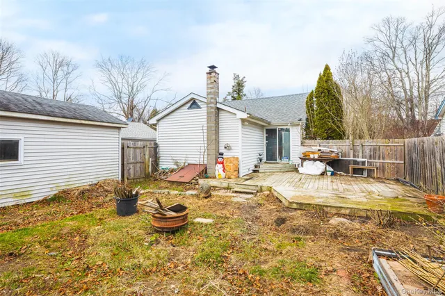 a view of a backyard with table and chairs potted plants and wooden fence